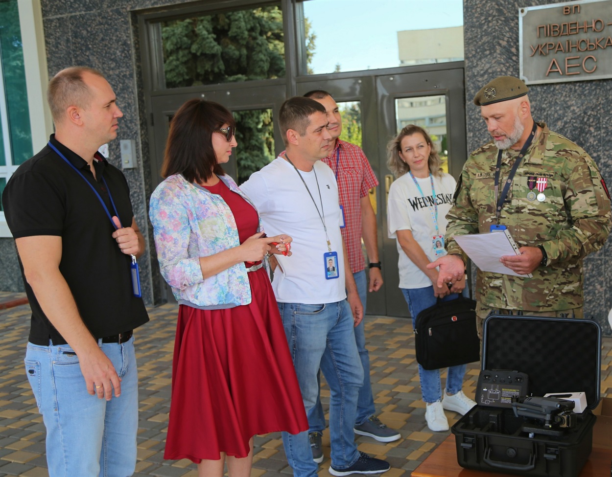 Працівник ПАЕС, військовослужбовець ЗСУ Андрій Дікусар спілкується з колегами під час отримання допомоги